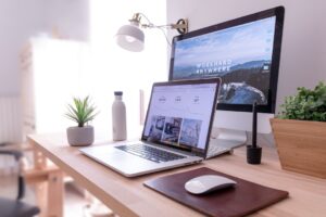 デスクのノートパソコンでグラフの並んだ画面を見ている様子