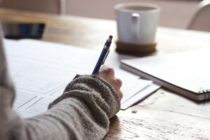 紙にページの構成を書き出して並べ替えている様子