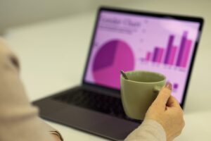 ノートパソコンのグラフを見ながら打ち合わせをする様子