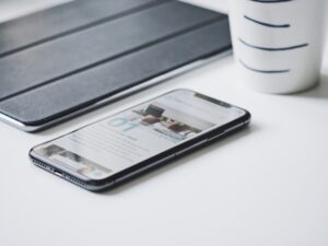 オフィスの机の上に置かれたスマートフォンとノートの様子